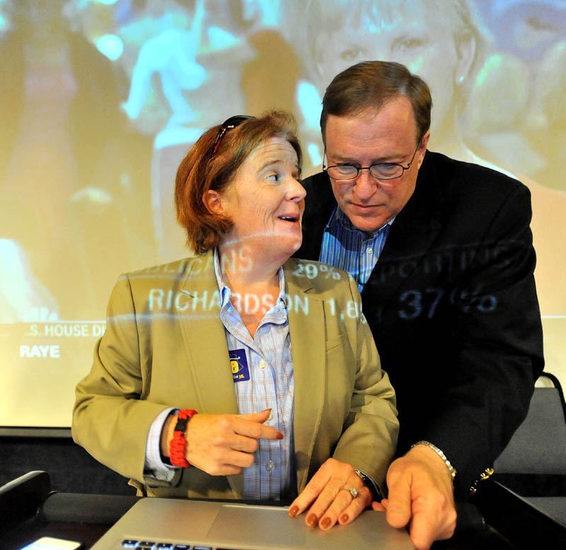 Staff photo by Michael G. Seamans Kevin Raye, candidate for US second congressional district, and his campaign consultant Kathie Summers read results at the Ramada Inn in Bangor Tuesday night.