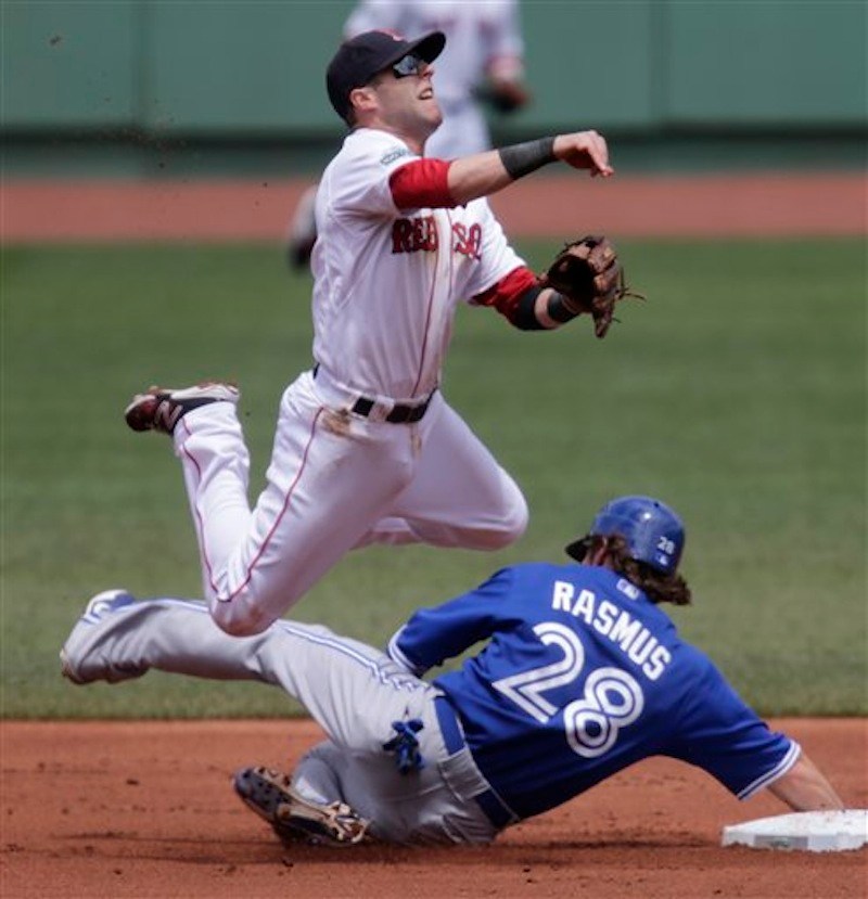 Boston Red Sox second baseman Dustin Pedroia leaps as he makes the force out on Toronto Blue Jays' Colby Rasmus on a grounder by teammate Jose Bautista in the first inning of a baseball game at Fenway Park in Boston, Wednesday, June 27, 2012. Bautista was safe at first. (AP Photo/Charles Krupa)