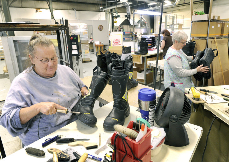 Laurie Auger cleans glue from boots prior to shipping.