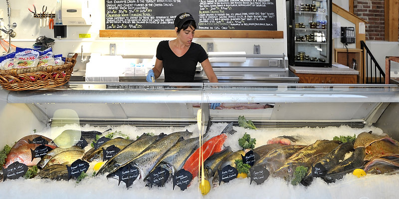 Rebecca Roy prepares monkfish for sale at Browne Trading Co. in Portland on Friday. Populations of cod and haddock in the Gulf of Maine are at such low levels that regulators intend to add them to a list of damaged stocks.