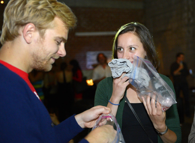 Konstantin Bakhurin, left, and Martina Desalvo smell shirts during a pheromone party Friday in Los Angeles. The get-togethers, which have been held in New York and Los Angeles and are planned for other cities, require guests to submit a slept-in T-shirt that will be sniffed by other participants. Then you can pick your partner based on scent.