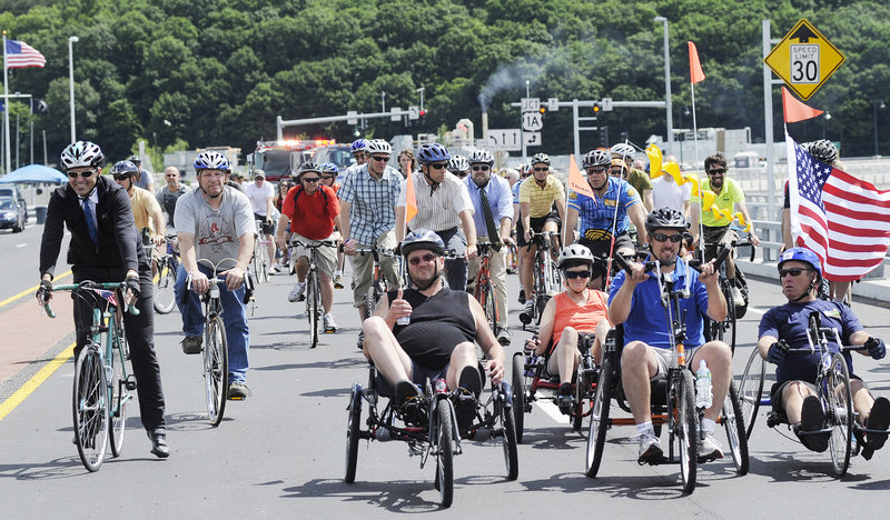 Cyclists cross Veterans Memorial Bridge before the opening ceremony Thursday.