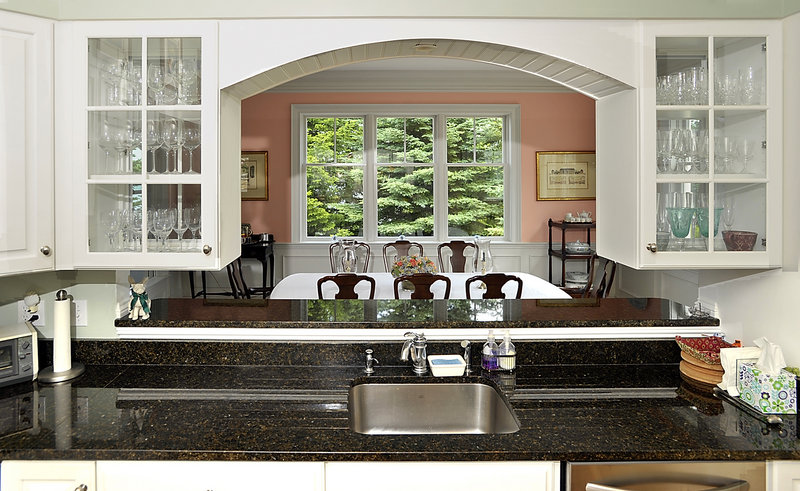 A view from the kitchen into the dining room and beyond to the fir trees outside.