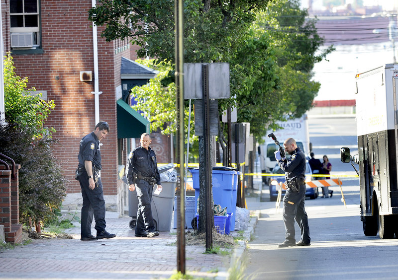 Police collect and photograph evidence outside 105-107 India St. Angelina Badalucco, who lives at the address, said people often hang out in a concrete area in the back of the apartment building, drinking and smoking. “I’m not surprised there was a confrontation and someone happened to have a weapon,” she said.