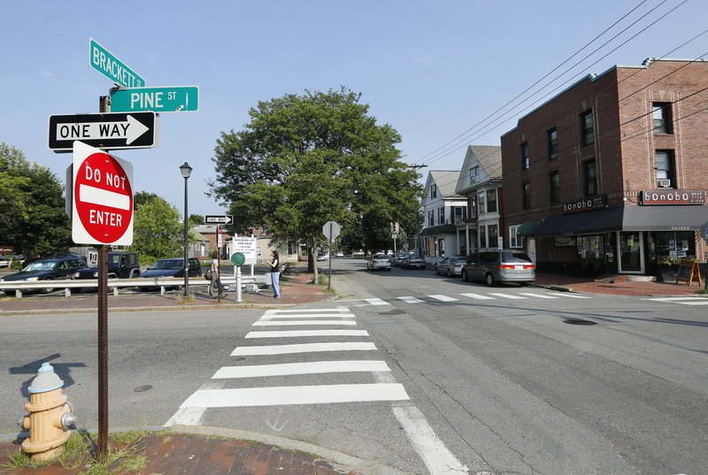 A crosswalk leads to the site at the corner of Pine and Brackett streets where a developer would put 39 market-rate apartments. Two old buildings would have to come down.