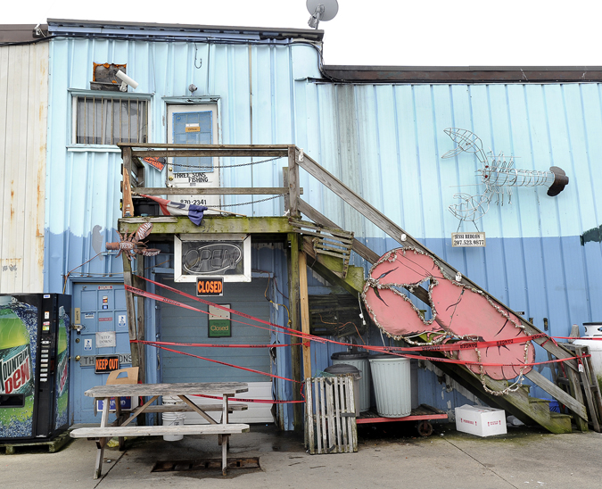 Red "danger" tape surrounds the entrance of Three Sons Lobster and Fish on Commercial Street today.