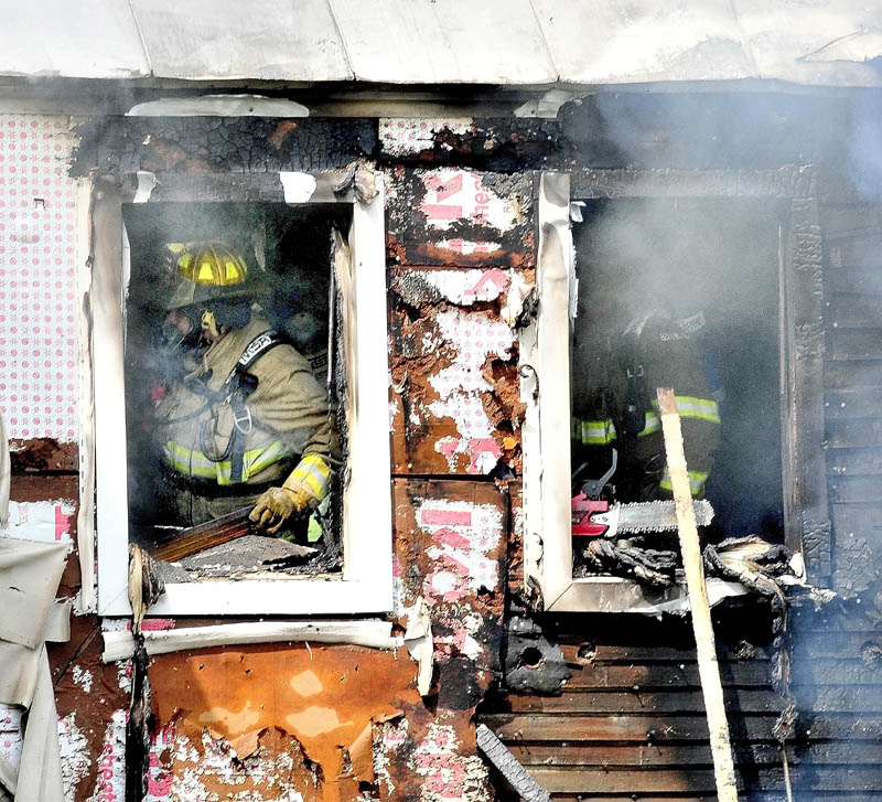 Firefighters search for fire inside a home that caused serious damage to the building on the Smithfield Road in Belgrade on Monday.