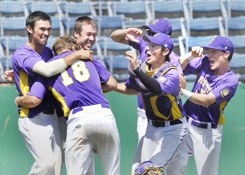 First Title’s Harry Ridge, No. 18, gets a big welcome at home after scoring the winning run on a sacrifice fly by Drew Ferrick in the bottom of the ninth at The Ballpark in Old Orchard Beach on Monday.