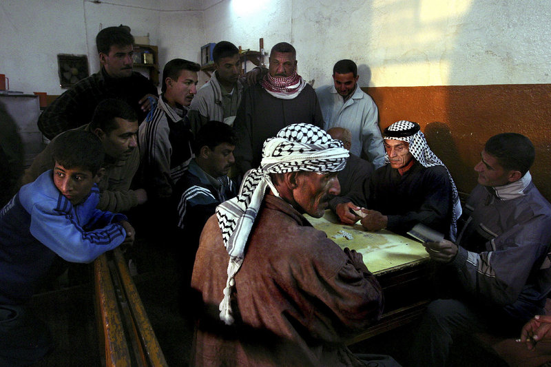 Iraqis play dominoes, a popular evening pastime, in Amara, Iraq, October 2003