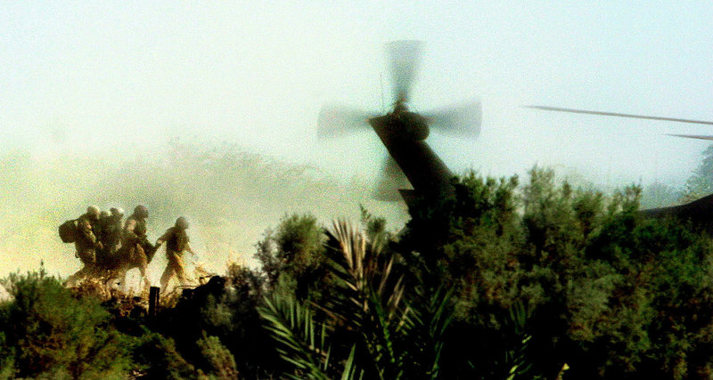 American soldiers carry a fallen comrade from the wreckage of a Chinook helicopter that was shot down by Suni insurgents in Fallujah, Iraq, October 2003