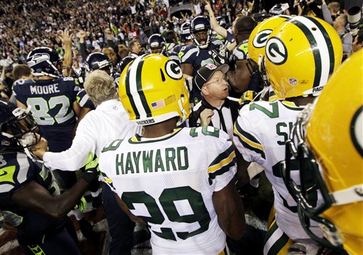 Officials try to sort out the final play of an NFL football game between the Green Bay Packers and the Seattle Seahawks as players and coaches swarm the field, Monday, Sept. 24, 2012, in Seattle. After a period of confusion, a Seahawks touchdown by wide receiver Golden Tate was allowed to stand for a 14-12 win. (AP Photo/Ted S. Warren) NFLACTION12;