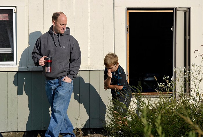 Brandon Cronin, 8, holds his nose after getting a whiff of his third-grade classroom at Hall School on Monday. He and his father, Wayne Cronin, were checking out the scene in the aftermath of a 1:30 a.m. fire that caused minor fire damage and more extensive water damage at the school.