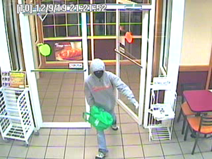 Surveillance image of robbery suspect entering the store. Police say the woman showed a black semi-automatic handgun to employees and demanded cash.