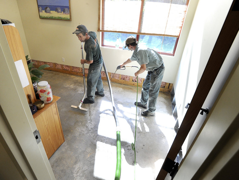 Roger Piper and Dave Ryan with Servpro clean Greener Postures Yoga on Friday after a water main break caused heavy damage to several South Portland businesses along Broadway.