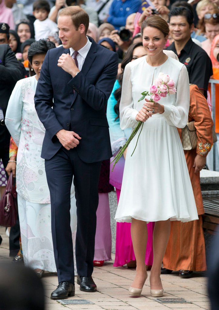 Prince William and his wife, Kate, walk in a Kuala Lumpur, Malaysia, park on Friday. The couple is suing a French magazine over published risque photos of the duchess.