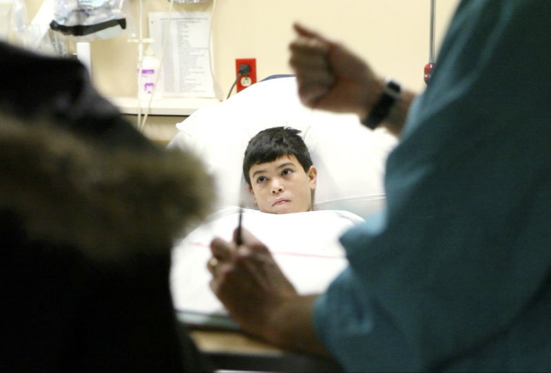 Jose listens as his mother and anesthesiologist Dan Landry talk before the surgery. Gift of Life International, a Rotary-affiliated program, arranged for Jose to have the operation for free.