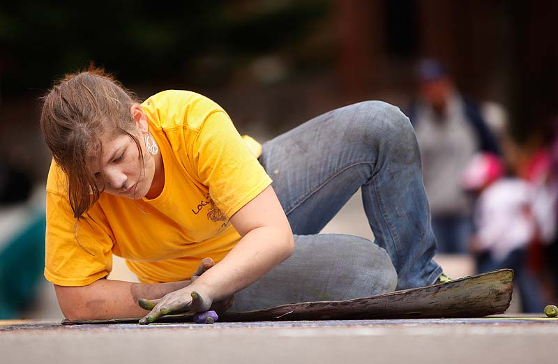 Shelby Braese, a junior at the University of New England, smudges chalk in a drawing she created on Adams Street in Biddeford during the eighth annual Chalk on the Walk Community Arts Festival on Saturday.