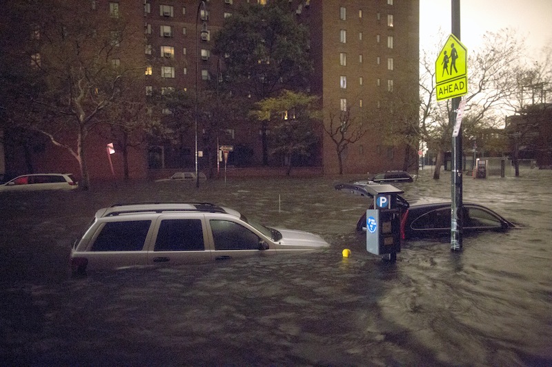 Vehicles are submerged on 14th Street near the Consolidated Edison power plant, Monday, Oct. 29, 2012, in New York. Sandy continued on its path Monday, as the storm forced the shutdown of mass transit, schools and financial markets, sending coastal residents fleeing, and threatening a dangerous mix of high winds and soaking rain.  (AP Photo/ John Minchillo)