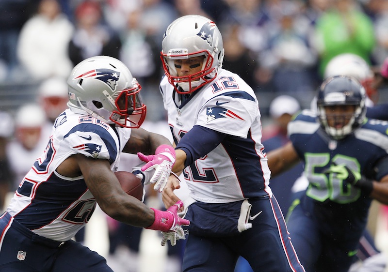 In this Oct. 14, 2012, photo, New England Patriots quarterback Tom Brady, center, hands off to Stevan Ridley during an NFL football game against the Seattle Seahawks in Seattle. The New York Jets face the Patriots on Sunday, Oct. 21. The Jets are taking on Brady and the Patriots' top-ranked up-tempo offense. The Patriots are also running the ball better than they have in recent years. (AP Photo/Elaine Thompson)