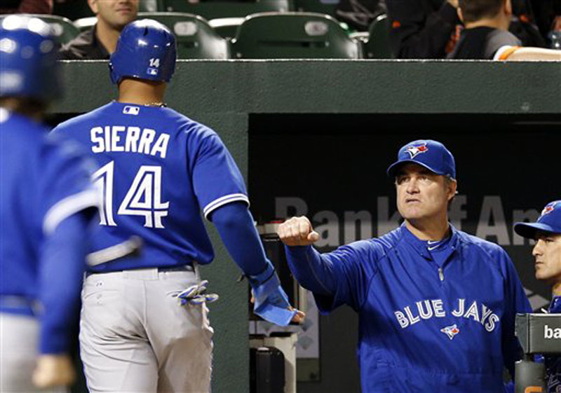 Toronto Blue Jays manager John Farrell, right, fist bumps Moises Sierra after Sierra scored a run on a sacrifice fly by J.P. Arencibia in the second inning of the second baseball game of a doubleheader against the Baltimore Orioles in Baltimore, Monday, Sept. 24, 2012. (AP Photo/Patrick Semansky)