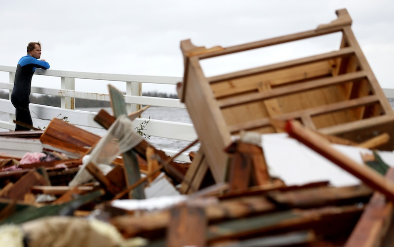 Currie Wagner looks at the wreckage of his grandmother Betty Wagner's house, which was destroyed and wound up resting on top of the Mantoloking Bridge the morning after hybrid storm Sandy rolled through, Tuesday, Oct. 30, 2012, in Mantoloking. New Jersey Gov. Chris Christie said Tuesday that the devastation on the New Jersey shore is "unthinkable" and that the state will likely take months to recover. (AP Photo/Julio Cortez)