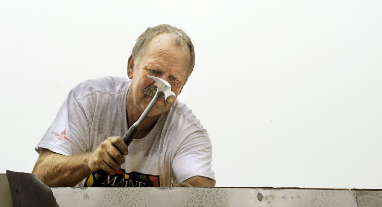 Bill Colby of Colby Contractors of South Portland works to seal the damaged roof of the Hall Elementary School on Tuesday, September 18, 2012, after a fire damaged the school early Monday morning.
