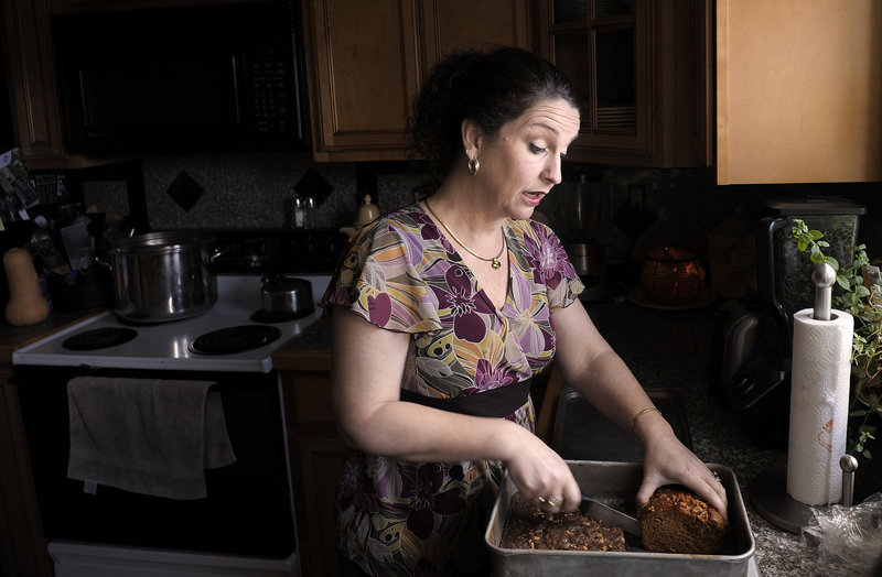 Catherine Lewis slices a piece of banana bread with marijuana as an ingredient for her husband, Glenn, at their Manchester home.