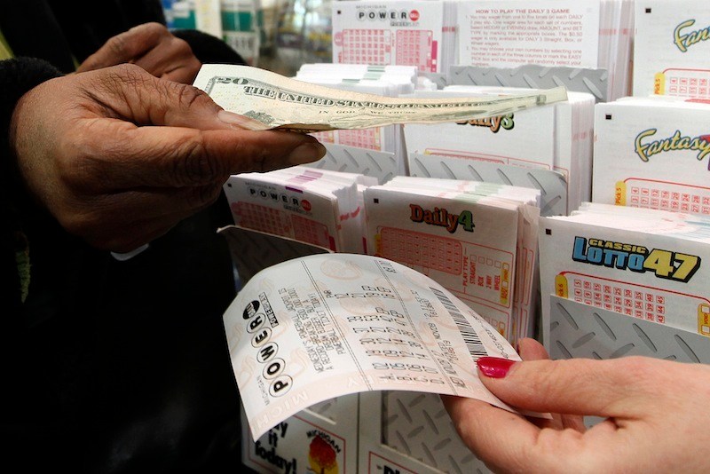 Donna Fields pays for her Powerball tickets in Detroit, Wednesday, Nov. 28, 2012. Fields picked two sets of numbers off the top of her head and two easy picks in tonight's Powerball total with an estimated $550 million jackpot. Fields said, "If I won I would take care of God first, then my family and do some travelling, and oh yeah, quit my job." (AP Photo/Paul Sancya)