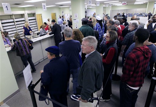 FILE - This Oct. 2,2012 file photo shows voters wait in line to pick up their ballots inside the Hamilton County Board of Elections after it opened for early voting, Tuesday, in Cincinnati. Stock up on munchies and make sure the batteries in your TV remote are fresh. With this year's presidential election razor-close to the finish, Tuesday could be a long night. Even if the presidency isn't decided until after midnight EST, there will be plenty of clues early in the evening on how things are going for President Barack Obama and Republican Mitt Romney. Obama has more options for piecing the 270 electoral votes needed for victory, so any early setbacks for Romney could be important portents of how the night will end. (AP Photo/Al Behrman, File)