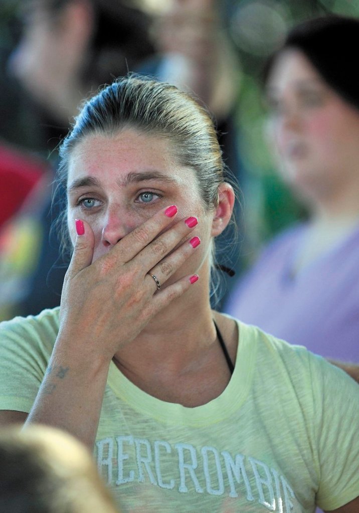 Janet White wipes away tears as she watches her apartment burn in August.