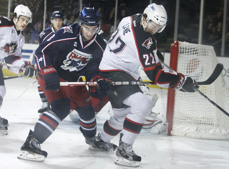 Phil Lane, left, of the Pirates battles with Springfield’s Cam Atkinson for the puck. The Pirates won by scoring two goals 26 seconds apart in the third period.