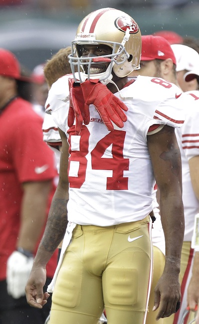 In this Sept. 30, 2012 file photo, San Francisco 49ers wide receiver Randy Moss smiles on the sideline during the second half of an NFL football game against the New York Jets in East Rutherford, N.J. Moss arrived at the New England Patriots five years ago thinking he knew a lot about football. Then, he began playing for Bill Belichick. Moss' mindset regarding his own football knowledge changed in a hurry. Only then did he learn the intricacies of his sport from "A to Z," as the 49ers wide receiver now puts it. (AP Photo/Kathy Willens, File)