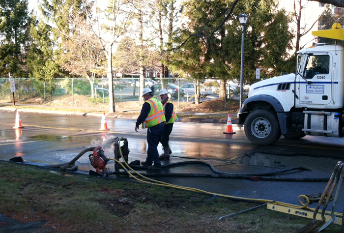 Workers on the scene of a water main break Monday on Pickett Street near Broadway in South Portland.