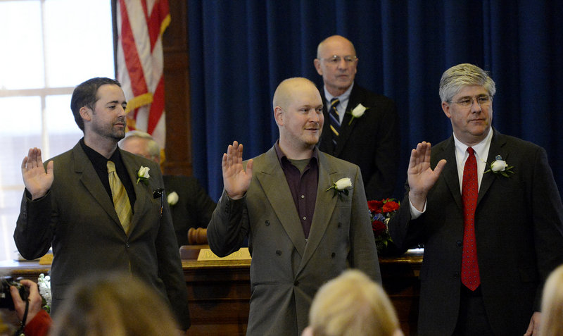 Re-elected Portland City Council members Kevin Donoghue, left, David Marshall, center, and Nick Mavodones are sworn in at Portland City Hall on Monday, Dec. 3, 2012. Looking on in the background is Mayor Michael Brennan.