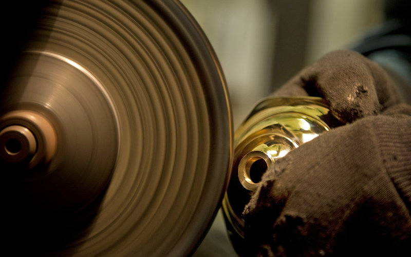 Mike Gutgsell, who owns The Polishing Shop that adjoins Allen’s business, polishes a brass candlestick.