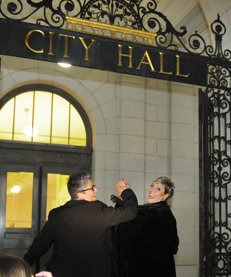 “The world's changing”: Donna Galluzzo, 49, left, and Lisa Gorney, 45, both of Portland, glance back toward friends after tossing a bouquet together shortly after being married early Saturday at Portland City Hall.