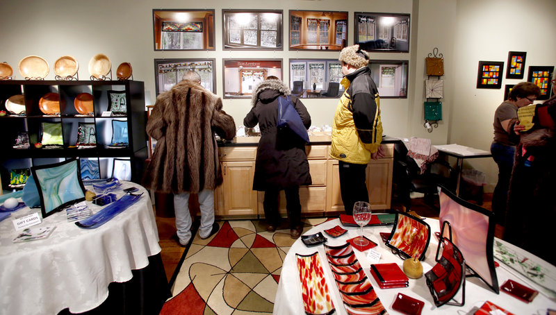 Visitors to dp Plourde Crafts look at glass wood art in the North Dam Mill during the monthly Biddeford ArtWalk on Friday. The ArtWalk, along with other art events, is helping to transform Biddeford into an arts community.