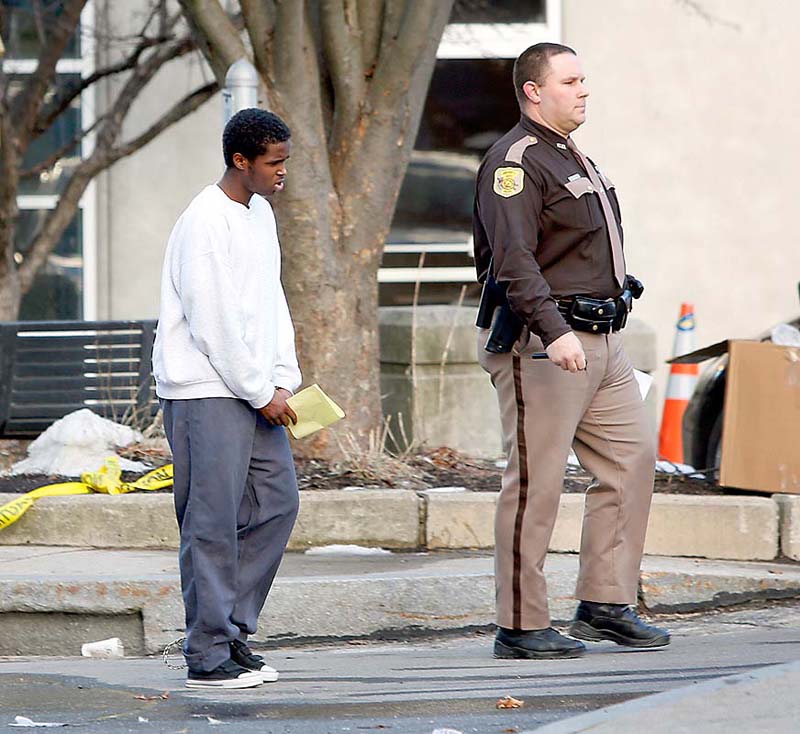 Tim Greenway/Staff Photographer: Mohammed Mukhtar is led away from the Cumberland County Courthouse after a juvenile court hearing on whether to prosecute Mukhtar as an adult or a juvenile in Portland on Monday afternoon January 14, 2013. Mukhtar is accused of breaking into a stranger's apartment and raping a woman as she slept.