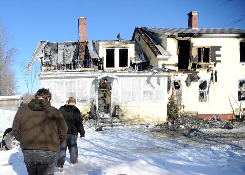 Cole Williams, 16, left, and his mother, Becky Williams, 40, tour what's left of a Madison Avenue home destroyed by fire around 3 a.m. Friday.