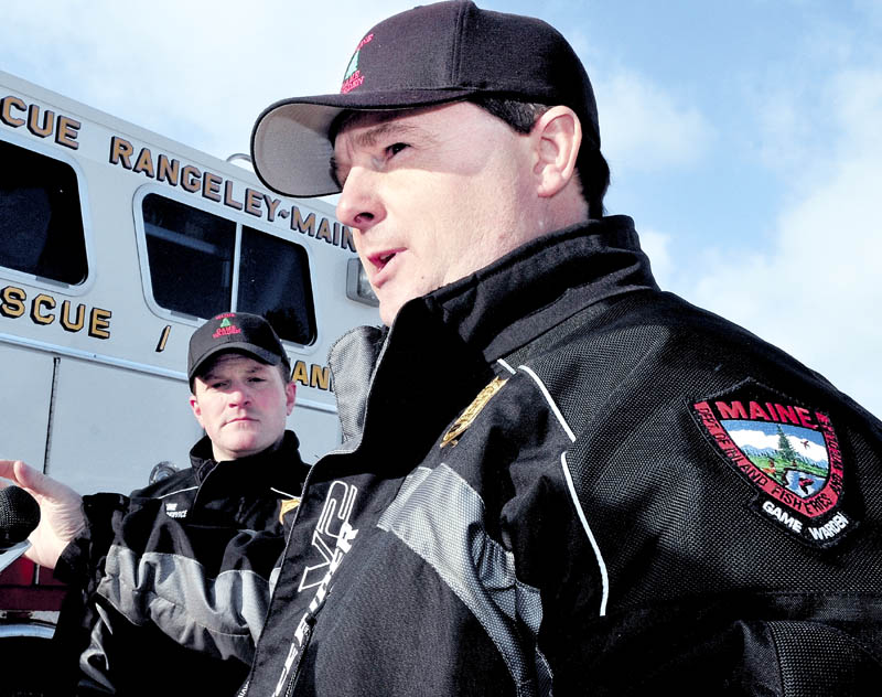 Staff photo by David Leaming RECOVERY: Maine Warden Service Lt. Kevin Adam, right, on Tuesday, January 1, 2013, speaks about the ongoing recovery of three more snowmobilers who went through the ice on Rangeley Lake in Rangeley last Sunday. Searchers recovered the body of Dawn Newell who also crashed through the ice. At left is MWS spokesman John MacDonald.