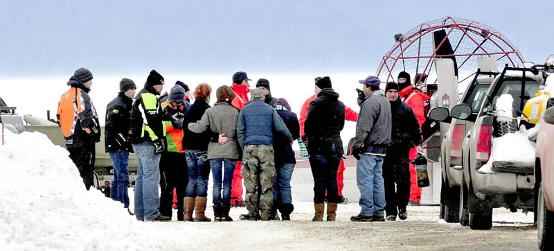 DEADLY ACCIDENT: People seen hugging and holding each other approach Maine Warden Service personnel wearing survival suits at the boat launch on Rangeley Lake on Monday. The body of Dawn Newell was recovered earlier in the day after her snowmobile went through the ice Sunday night.