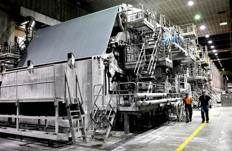 Sappi papermakers Alan Kenney, left, and Tom Staples walk past the huge No. 3 at the Skowhegan mill on Thursday.