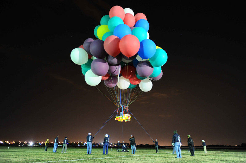 Jonathan Trappe takes off on a test flight in a Portland-made dinghy attached to balloons at the Leon International Balloon Festival in November in Leon, Mexico. He says he will need 365 balloons to keep him aloft for a trip across the Atlantic this summer.