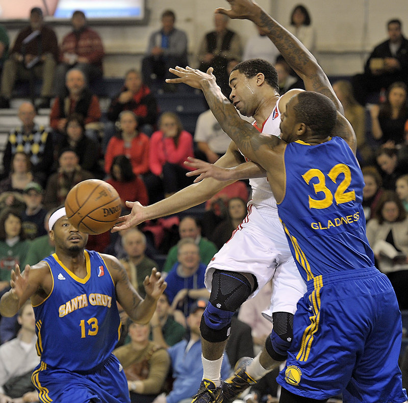 Maine’s Andre Barrett finds himself surrounded by Warriors Mickell Gladness (32) and Stefhon Hannah (13) during Friday’s loss to Santa Cruz.