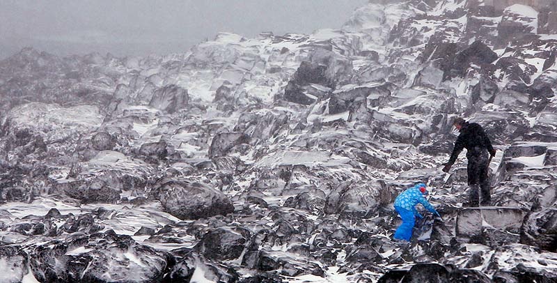 Roger Olson holds out a hand to his daughter Gianna while the two explore the snow-covered rocks at Mother's Beach in Kennebunk on Friday, Feb. 8, 2013.