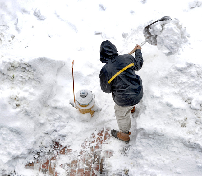 Federal Spice owner and cook Eric Martin does his part by helping the Fire Department clear the hydrant in front of his Federal Street eatery on Monday.