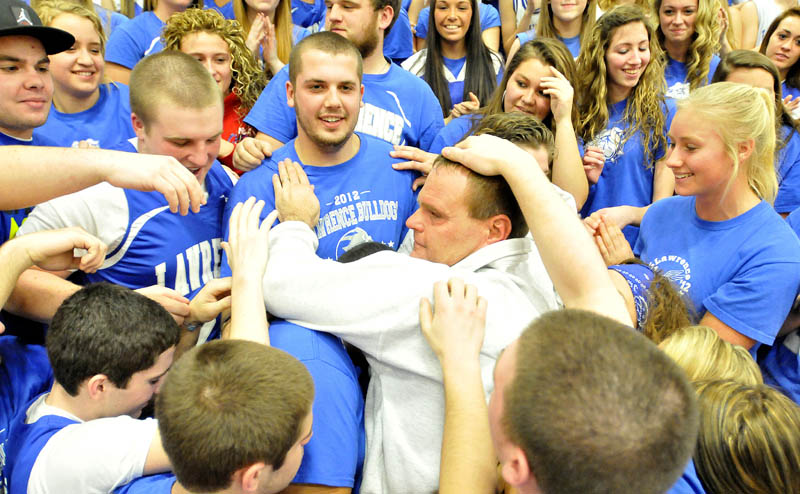 THANKS: Lawrence High School basketball coach Mike McGee has a group hug with the Rowdies, Lawrence’s student cheering section prior to the Bulldogs game against Skowhegan on Thursday. McGee, who is retiring after the season, was honored before the game.