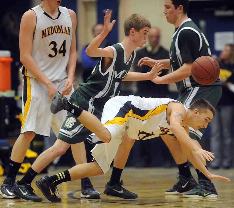 MDI's Jonathan Phelps, 10, fouls Medomak Valley's Brandon Soper, 11, in the final minutes of the Eastern Class B championship game at the Bangor Auditorium on Saturday.