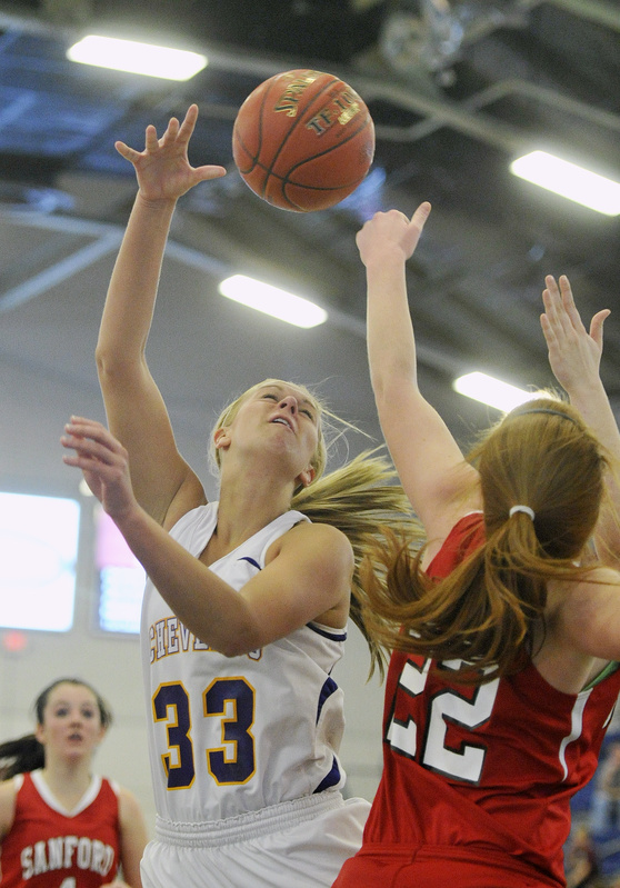 Heather LeBlanc, right, of Sanford knocks away a shot by Kylie Libby of Cheverus during their Western Class A quarterfinal Monday at the Portland Expo. Cheverus came away with a 31-26 victory.