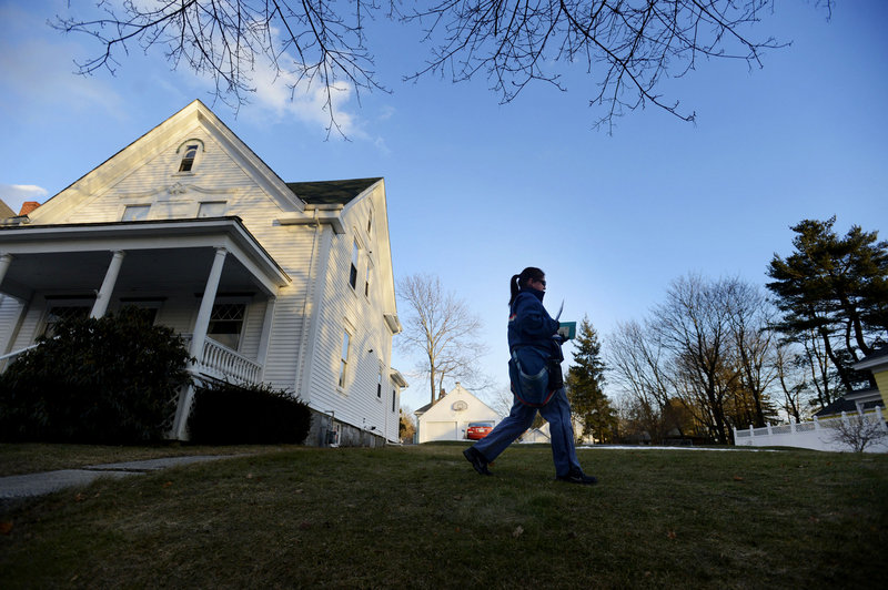 Mail carrier Carrie Estes delivers mail on Bradley St. in Portland late in the day Wednesday, February 6, 2013. The U.S. Postal Service will stop delivering mail on Saturdays in an effort to save about $2 billion annually.